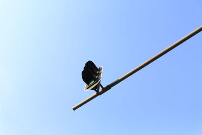 Low angle view of street light against blue sky