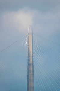 Low angle view of suspension bridge against sky