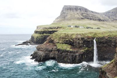 Scenic view of rock formation in sea against sky