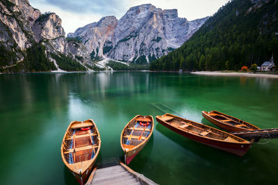 Boats moored in lake against mountains