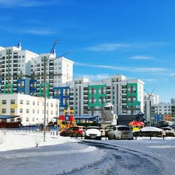 Buildings in city against sky during winter