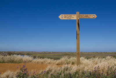 Information sign on field against clear sky