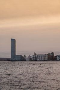 Kayakers at residential area aarhus Ø and lighthouse, denmark