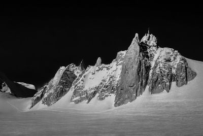 Snow covered mountain against sky at night