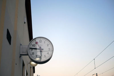 Low angle view of clock on building against clear sky