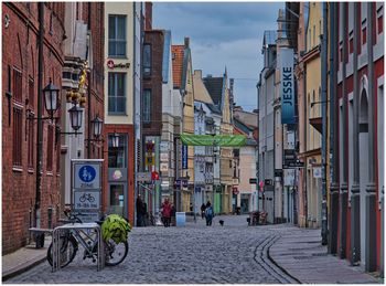 Street amidst buildings in city against sky