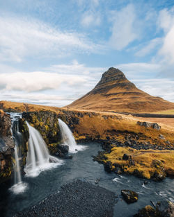 Scenic view of waterfall against sky during sunset