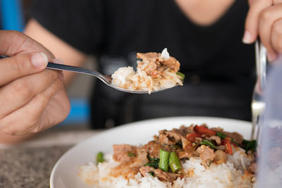 Close-up of woman eating food in plate