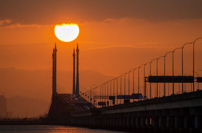 Silhouette bridge against sky during sunset