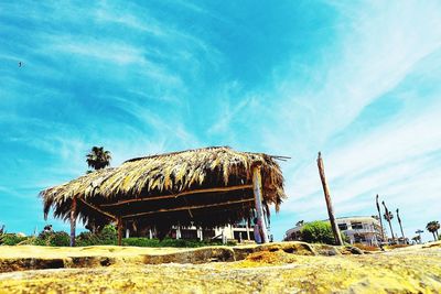 Low angle view of hut at beach against sky