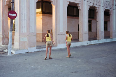 Full length of a man with woman walking in front of building