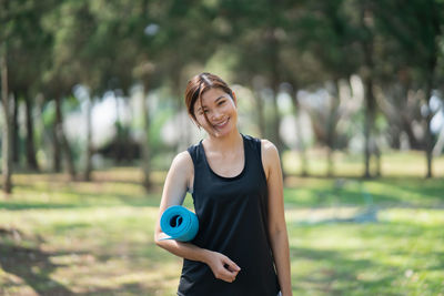 Portrait of smiling young woman standing on field