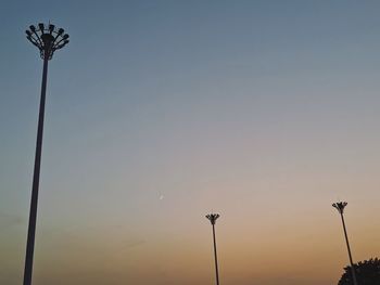 Low angle view of street lights against sky during sunset