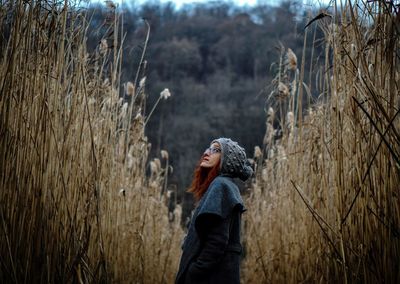 Side view of woman standing on reed field