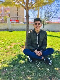 Portrait of smiling boy sitting on lawn