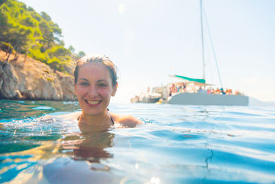 Portrait of smiling young woman swimming in pool