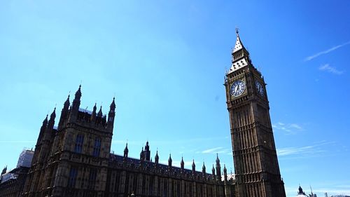 Low angle view of clock tower against blue sky