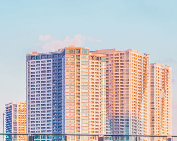 Low angle view of modern buildings against blue sky