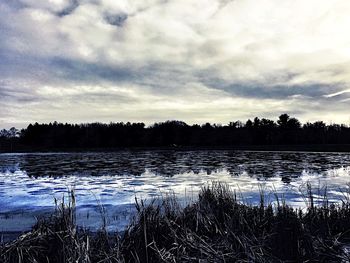 Scenic view of lake against cloudy sky