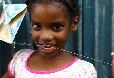 Close-up portrait of girl with thread in mouth