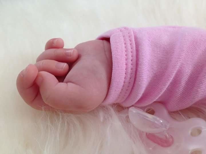 person, indoors, part of, cropped, human finger, close-up, holding, lifestyles, fragility, freshness, baby, unknown gender, babyhood, childhood, high angle view, nail polish