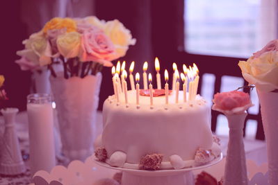 Lit candles on birthday cake at home