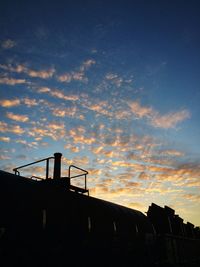 Low angle view of silhouette built structure against sunset sky