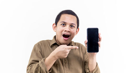 Portrait of mature man using smart phone against white background