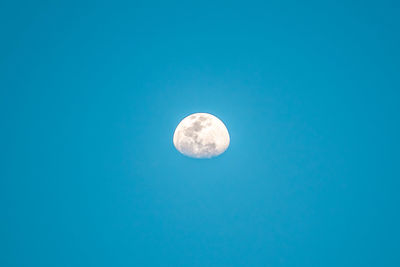 Low angle view of moon against blue sky