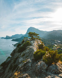 Scenic view of sea and mountains against sky