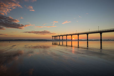 Pier on sea at sunset