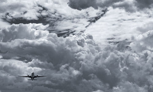 Airplane flying on dark sky and white fluffy cloud. commercial airline with dream destinations.