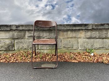 Empty bench against wall