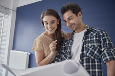 Young couple standing against the wall