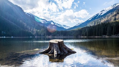 Scenic view of lake by snowcapped mountains against sky