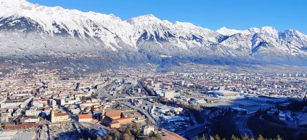 High angle view of townscape against snowcapped mountains