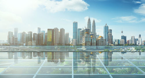 Modern buildings by swimming pool against sky