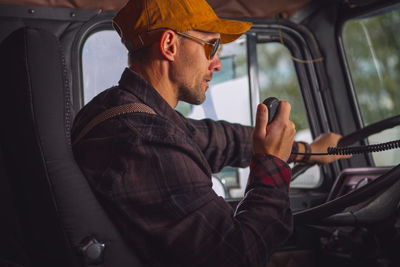 Side view of man sitting in car