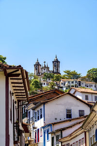 Buildings in city against clear blue sky