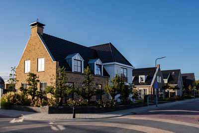 Houses by road against sky in city