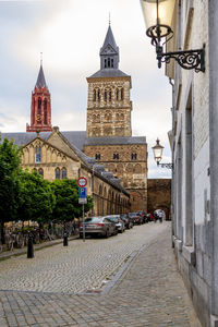 View of street amidst buildings in city, maastricht, netherlands