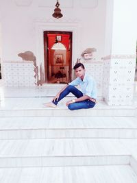 Young man looking down while sitting on floor