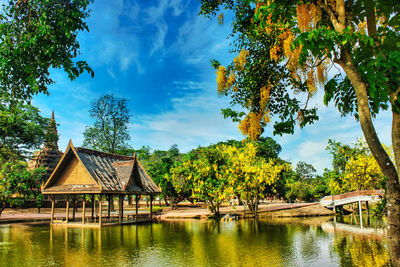 House by lake against sky