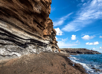 Rock formations by sea against sky