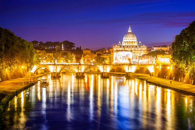 Illuminated bridge over river at night