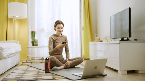 Young woman using mobile phone at home