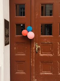 Close-up of red balloons with closed door