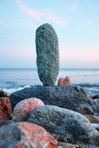 Close-up of pebbles on beach against sky