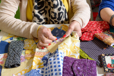 Midsection of woman stitching fabric