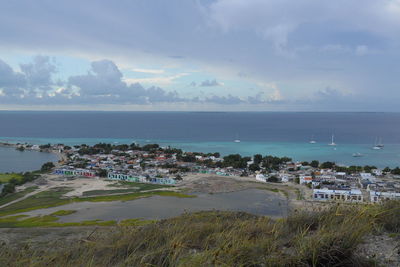 High angle view of cityscape by sea against sky